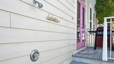 a house with a pink door and a grill at Pink Flamingo in Panama City Beach