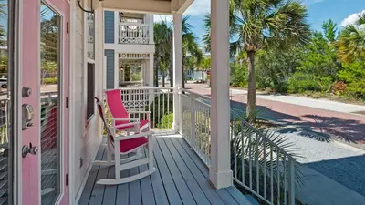 a porch with two chairs on a house at Pink Flamingo in Panama City Beach