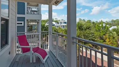 a porch with a pink chair on a balcony at Pink Flamingo in Panama City Beach