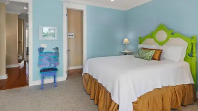 a bedroom with a large bed and a blue wall at Pink Flamingo in Panama City Beach