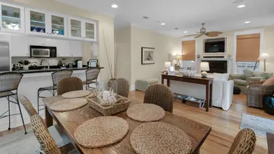 a kitchen and living room with a table and chairs at Quietude in Santa Rosa Beach