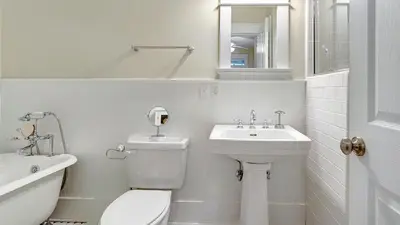 a white bathroom with a toilet and a sink at Quietude in Santa Rosa Beach