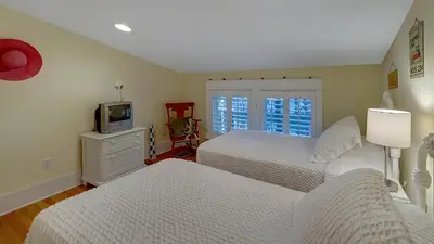 a bedroom with two beds and a tv on a dresser at Quietude in Santa Rosa Beach