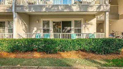 a house with a hedge in front of it at Rollin Tide C2 - Seaglass Sands in Santa Rosa Beach