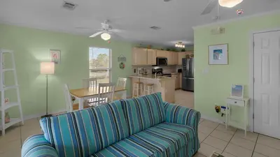 a living room with a couch and a kitchen at Rollin Tide C8 in Santa Rosa Beach