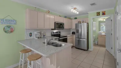 a kitchen with a sink and a refrigerator at Rollin Tide C8 in Santa Rosa Beach