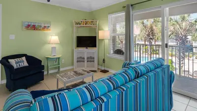 a living room with a blue couch and a television at Rollin Tide C8 in Santa Rosa Beach