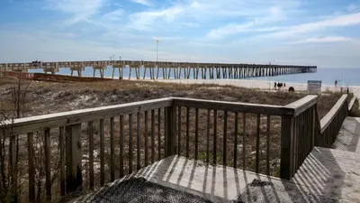a beach with a pier and the ocean at Leo's Hideaway in Panama City Beach