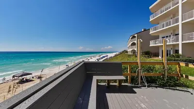 a bench on a boardwalk next to a beach at Sago Sands 402 in Santa Rosa Beach