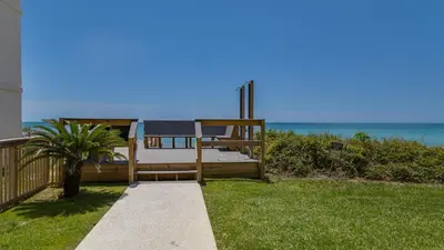 a bed on a porch with the ocean in the background at Sago Sands 402 in Santa Rosa Beach