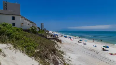 a beach with umbrellas and people on the sand at Sago Sands 402 in Santa Rosa Beach