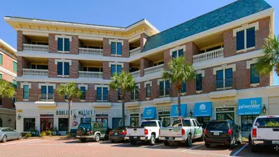 a large brick building with cars parked in a parking lot at Village of South Walton 314D - Serenity in Rosemary Beach