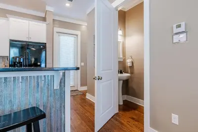 a kitchen with a counter and a bathroom with a sink at Lifeguard Loop in Rosemary Beach
