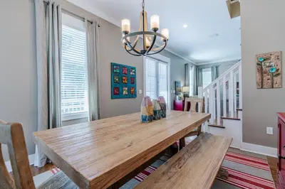a dining room with a wooden table and benches at Lifeguard Loop in Rosemary Beach