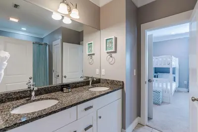 a bathroom with two sinks and a large mirror at Lifeguard Loop in Rosemary Beach
