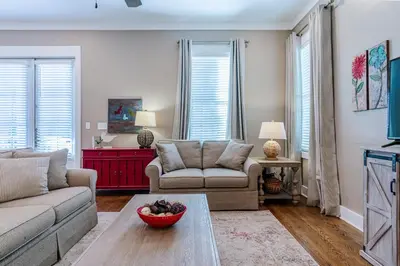 a living room with a couch and a table at Lifeguard Loop in Rosemary Beach