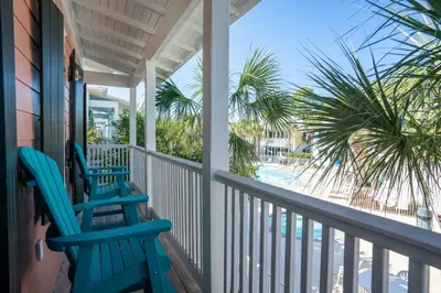 two blue chairs on a porch with a view of the beach at Salty Paws Bungalow in Santa Rosa Beach