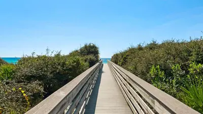 a wooden boardwalk leading to the ocean on a beach at Salty Paws Bungalow in Santa Rosa Beach