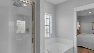 a white bathroom with a shower and a bed at Seaview II #200 in Santa Rosa Beach
