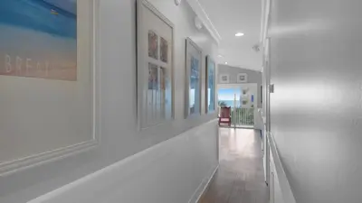 a hallway with white walls and paintings on the walls at Seaview II #200 in Santa Rosa Beach