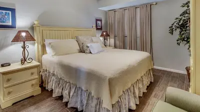 a bedroom with a bed and a table with a lamp at Tranquillity 220 in Panama City Beach