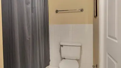 a bathroom with a toilet with a shower curtain at Tranquillity 220 in Panama City Beach