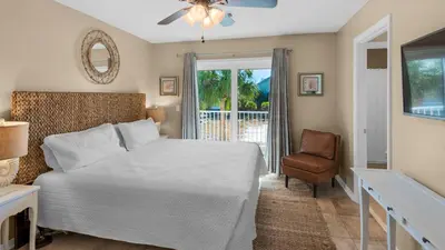 a bedroom with a bed and a chair and a window at Beachside Villas 1122 in Santa Rosa Beach