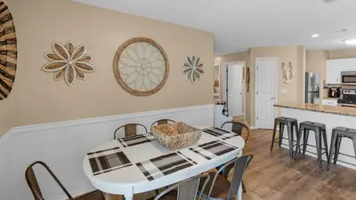 a kitchen and dining room with a white table and chairs at Beachside Villas 1122 in Santa Rosa Beach