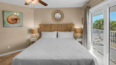 a bedroom with a bed and a balcony at Beachside Villas 1122 in Santa Rosa Beach