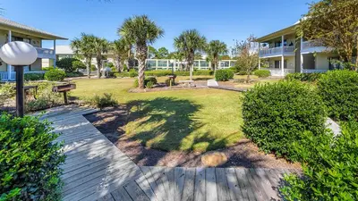 a walkway through a yard with trees and a building at Beachwood Villas 3A in Santa Rosa Beach