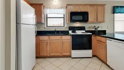a kitchen with wooden cabinets and a white refrigerator at Beachwood Villas 3H in Santa Rosa Beach