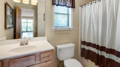 a bathroom with a sink and a toilet and a mirror at Beachwood Villas 3H in Santa Rosa Beach