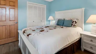 a bedroom with a white bed and blue walls at Beachwood Villas 3H in Santa Rosa Beach