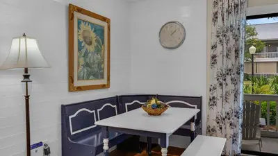 a dining room with a table and a clock on the wall at Beachwood Villas 4C in Santa Rosa Beach