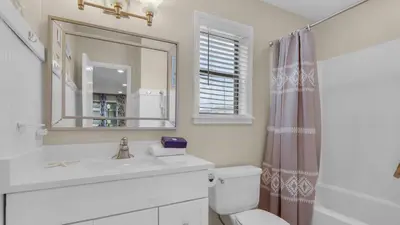 a bathroom with a sink and a toilet and a mirror at Beachwood Villas 4C in Santa Rosa Beach