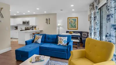a living room with a blue couch and yellow chairs at Beachwood Villas 4C in Santa Rosa Beach