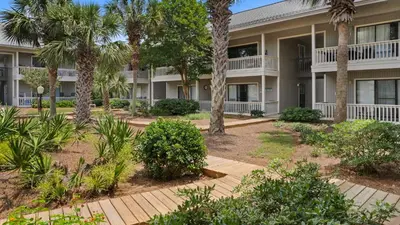 a building with palm trees in front of it at Beachwood Villas 4C in Santa Rosa Beach