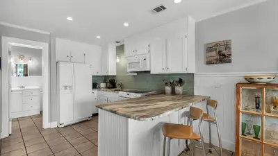 a kitchen with white cabinets and a counter top at Beachwood Villas 8D in Santa Rosa Beach