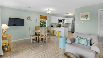 a living room with a couch and a table and a kitchen at Beachwood Villas 9B in Santa Rosa Beach