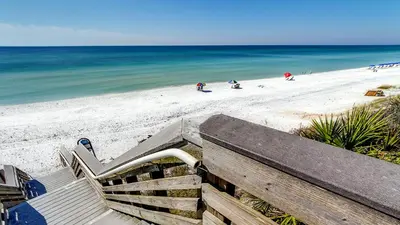 a bench on the beach with the ocean in the background at Beachwood Villas 13A in Santa Rosa Beach