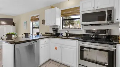 a kitchen with white cabinets and stainless steel appliances at Beachwood Villas 13A in Santa Rosa Beach