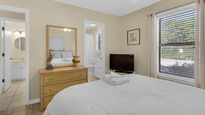 a bedroom with a large bed and a television at Beachwood Villas 13A in Santa Rosa Beach