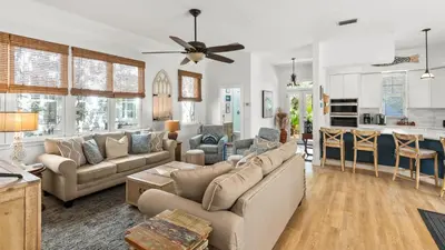 a living room with couches and a kitchen at Crow's Nest in Santa Rosa Beach