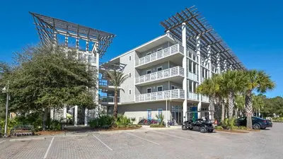 a white apartment building with a parking lot at Cassine Station 302 in Santa Rosa Beach