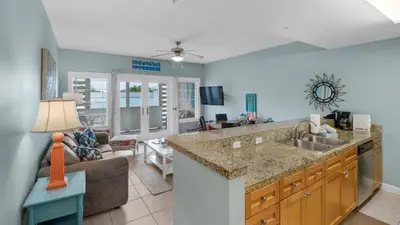 a kitchen with a sink and a living room at Cassine Station 302 in Santa Rosa Beach