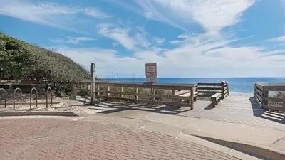 a bench on a boardwalk next to the beach at Cassine Station 302 in Santa Rosa Beach