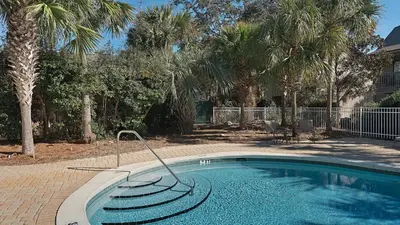 a swimming pool in a yard with palm trees at Cassine Station 302 in Santa Rosa Beach
