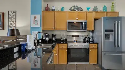 a kitchen with stainless steel appliances and wooden cabinets at Dunes Of Seagrove 202C in Santa Rosa Beach