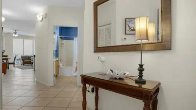 a living room with a table and a mirror at Dunes Of Seagrove 202C in Santa Rosa Beach