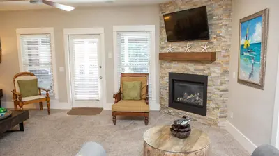a living room with a fireplace and a tv at Dolphin House in Santa Rosa Beach